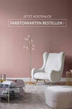 a living room with two white chairs and a coffee table in front of a pink wall