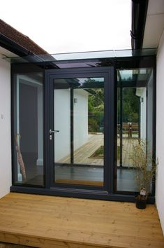 an open patio with wooden flooring and sliding glass doors on the side of it