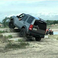 a gray truck driving down a dirt road