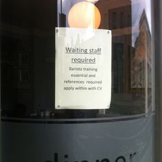 a sign that is on the side of a glass door saying, waiting staff required