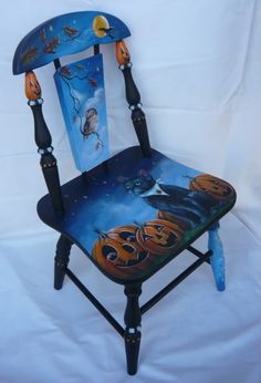 a painted halloween themed chair with pumpkins and cats on it, against a white background