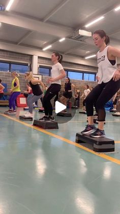 a group of people in a gym doing exercises on their skateboards with one person standing up