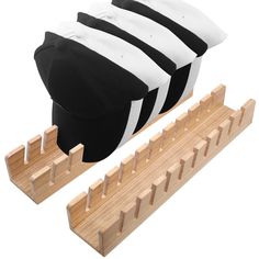 a black and white hat sitting on top of a wooden rack