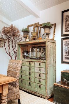 an old dresser in a room with pictures on the wall