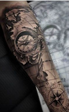 a man's arm with a compass tattoo on it