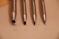 four metal pens sitting on top of a table