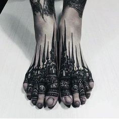 the legs and feet of a person with tattoos on their arms, both covered in black ink