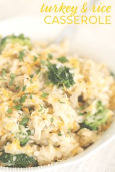 a white bowl filled with rice and broccoli on top of a table next to a fork