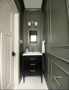 a bathroom with gray walls and gold trim on the mirror, sink, and vanity