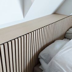 a bed sitting under a window next to a wooden radiator