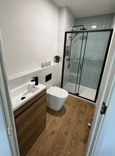 a bathroom with wooden floors and white walls