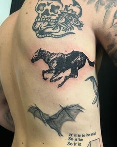 a man's back with tattoos on it and a horse in the middle of his left arm