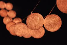 string lights are hanging from strings in the dark, with balls on each strand and round ones at the end