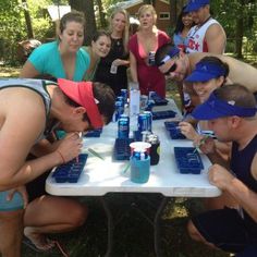 a group of people sitting around a table with drinks and water bottles on top of it