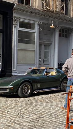 a man standing next to a green sports car