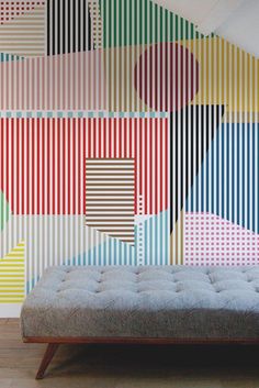 a bed sitting in front of a colorful wall