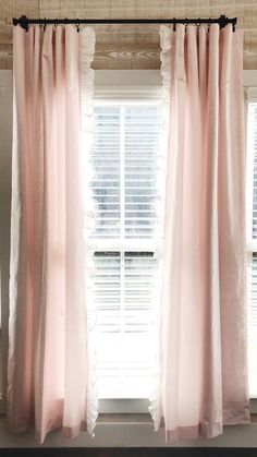 pink curtains hanging in front of a window