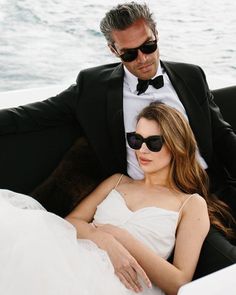 a man in a tuxedo sitting next to a beautiful woman on a boat