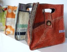 three purses sitting on top of a white shelf next to each other in different colors