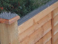 a wooden fence with spikes sticking out of it