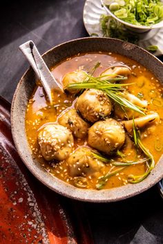 a bowl filled with soup and meatballs on top of a table