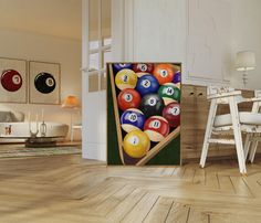 a billiards pool table full of balls in a room with white walls and wooden floors