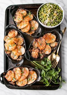 the meal is prepared and ready to be eaten on the grill, including shrimp, peas, and potatoes