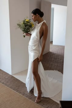 a woman in a white dress holding flowers