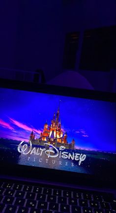 a laptop computer sitting on top of a desk with the disney logo on it's screen