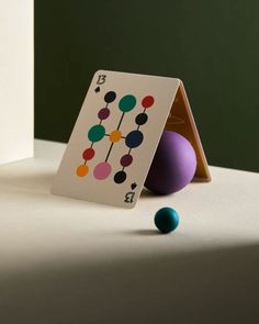 a card and two balls on a table