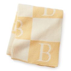 a yellow and white blanket with the letter b on it