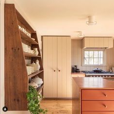 a kitchen with wooden cabinets and shelves filled with dishes on top of eachother