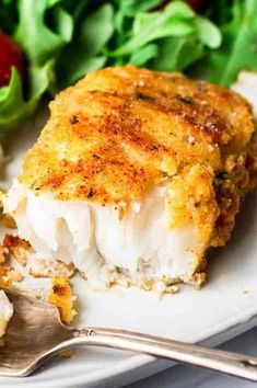 a close up of a plate of food with fish and salad in the back ground