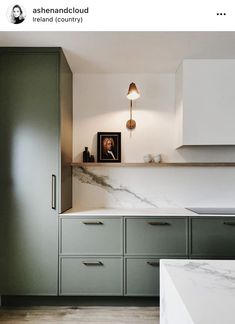 a kitchen with green cabinets and marble counter tops