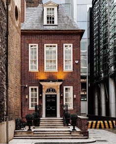 an old brick building in the middle of a city with stairs leading up to it