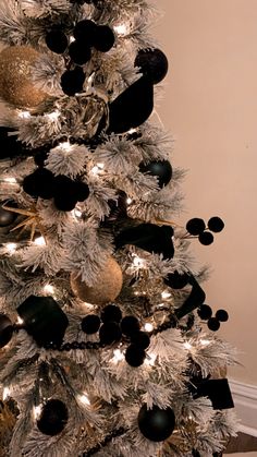 a white christmas tree with black and gold ornaments