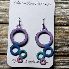 purple and blue earrings with circles hanging from it's earwires on a wooden background