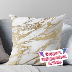 a white and gold marble throw pillow with the words support independent artists printed on it