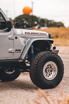 a silver jeep parked on top of a parking lot