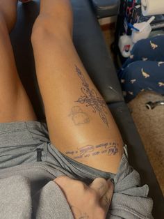 a person with tattoos on their legs laying down