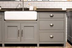 a kitchen sink sitting next to a counter top under a faucet mounted on a wall