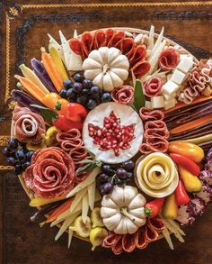 an arrangement of fruits, vegetables and meats arranged in the shape of a maple leaf