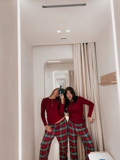 two women in red shirts and plaid pants taking a selfie