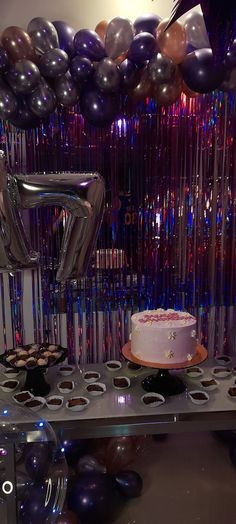 a birthday cake and balloons on a table