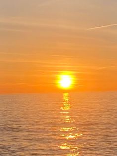 the sun is setting over the ocean as it reflects in the water