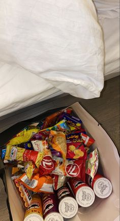 an open box filled with snacks on top of a bed