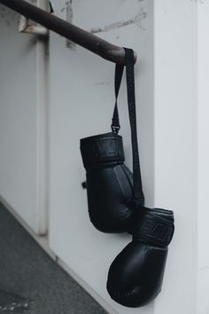 two black boxing gloves hanging on a wall