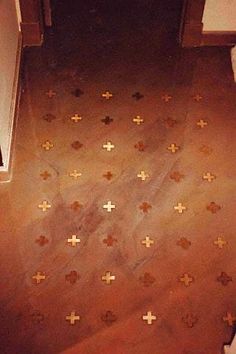 the floor in this bathroom has crosses painted on it