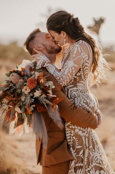 a bride and groom kissing in the desert