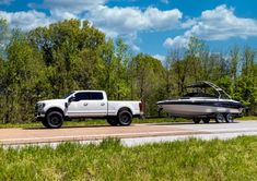 a white truck towing a boat on the road